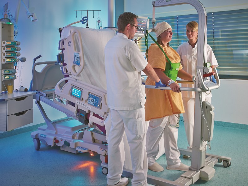 Physicians helping a patient to stand up