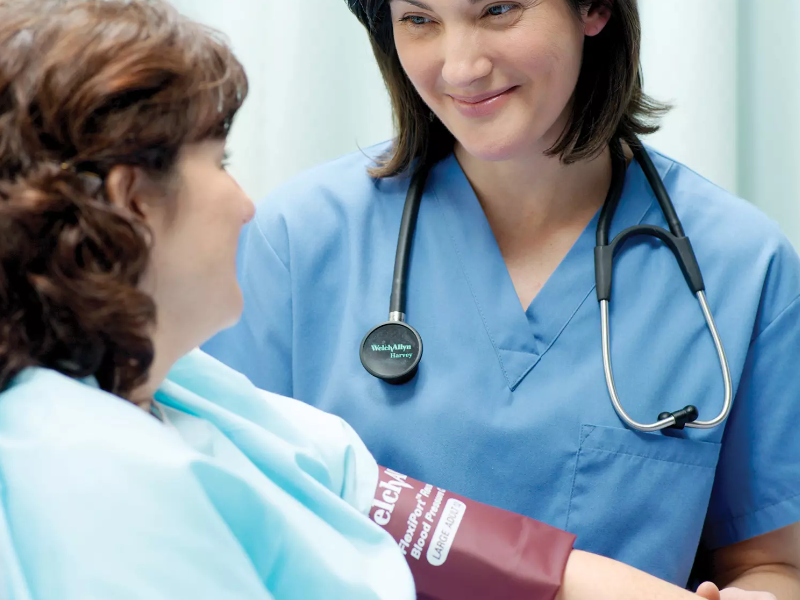 A nurse using the flexiport reusable blood pressure cuff on a patient.