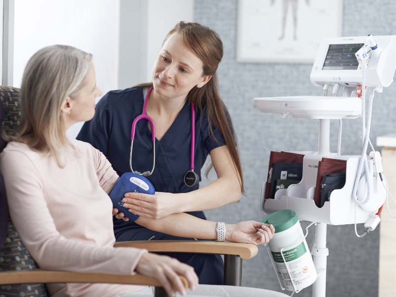 A nurse checking a patients blood pressure.
