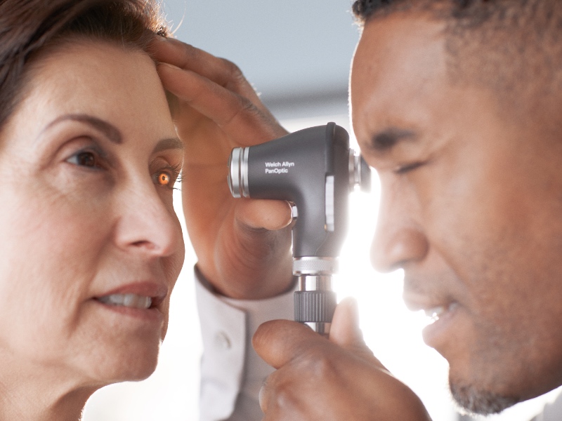 A doctor inspecting a patients eye using Pan-Optic Plus.