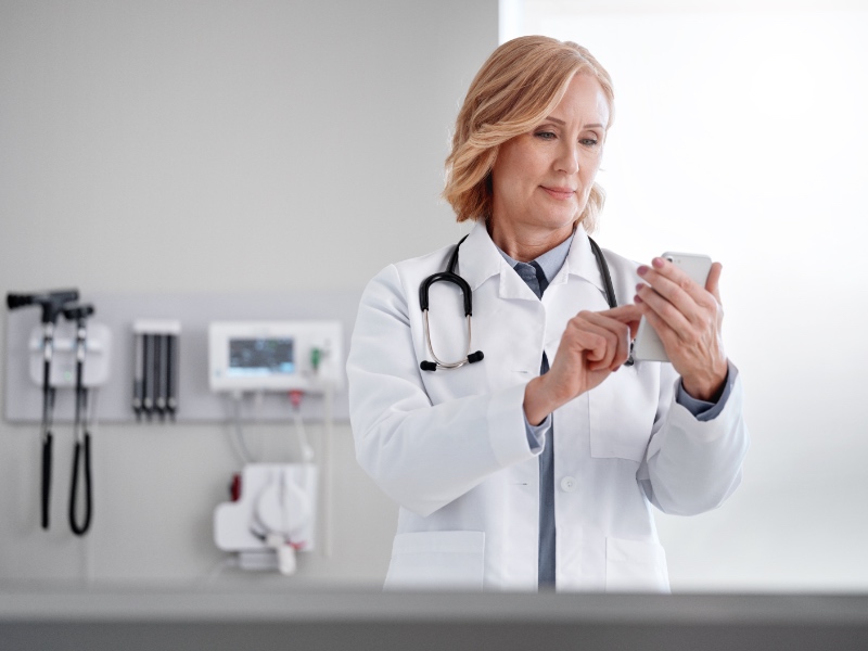 A doctor using their mobile device in a hospital.