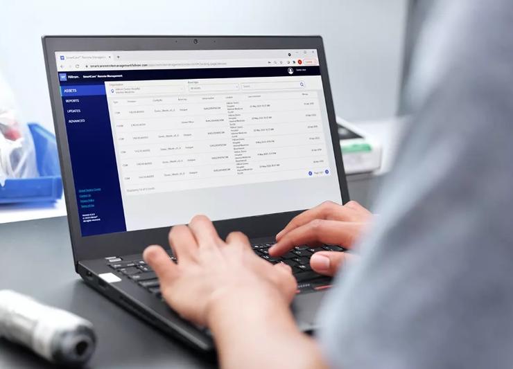 Man looking at laptop with data about his patients on the screen.
