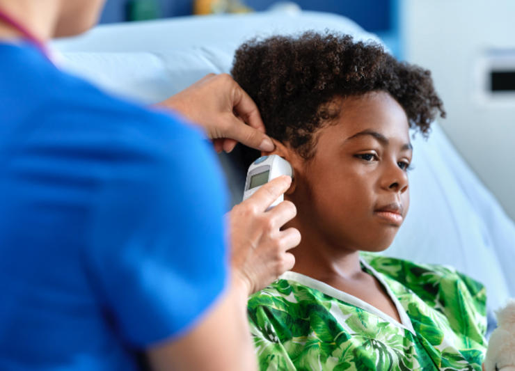 A nurse checking a child's temperature.
