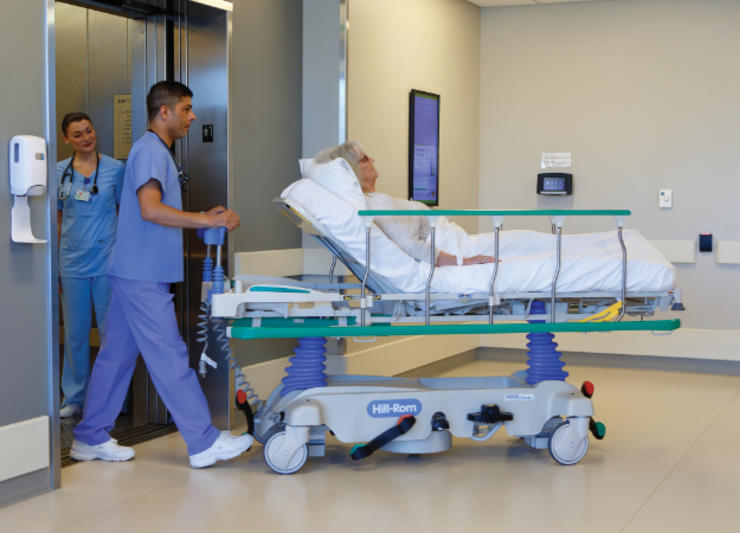 A nurse pushing a patient in a hospital bed.