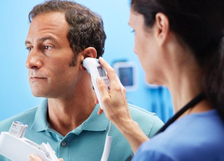 A doctor checking a patients temperature using a thermometer.