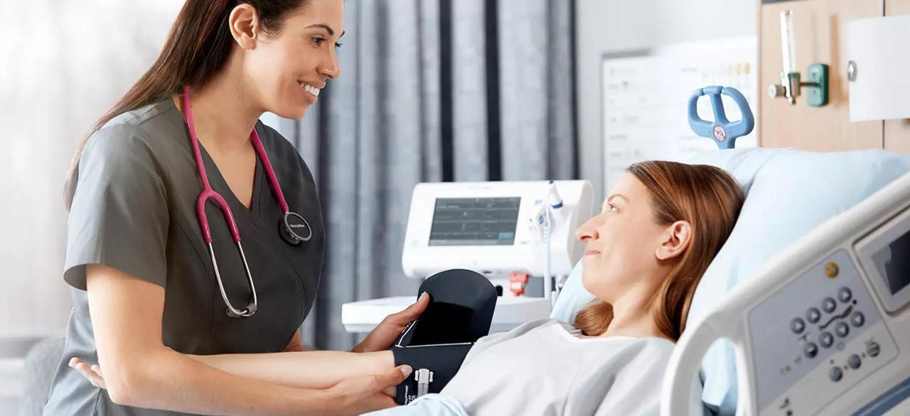 A nurse and bed patient talking to each other