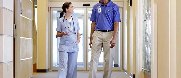 Female and male physicians walking in clinic